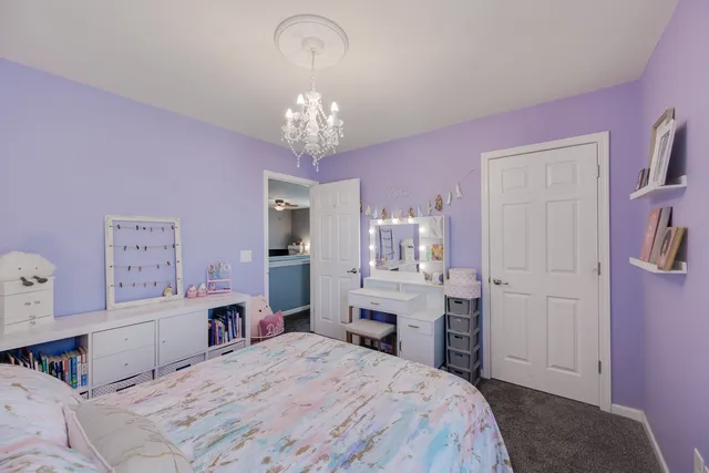 a spacious bedroom with a bed and chandelier