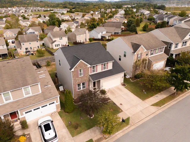 an aerial view of a city with lots of residential buildings and ocean view in back