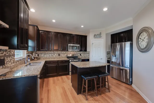 a kitchen with granite countertop a sink stove and refrigerator