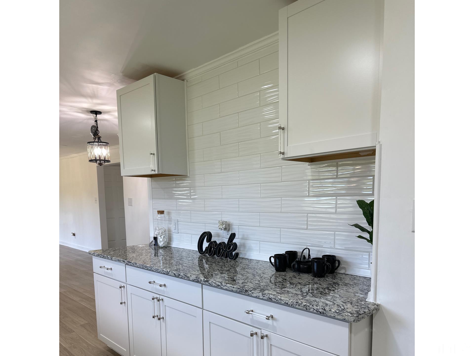 216 Trinity Church Road Louisburg, NC 27549 - Photo 9 of 28 a kitchen with stainless steel appliances granite countertop white cabinets and a potted plant