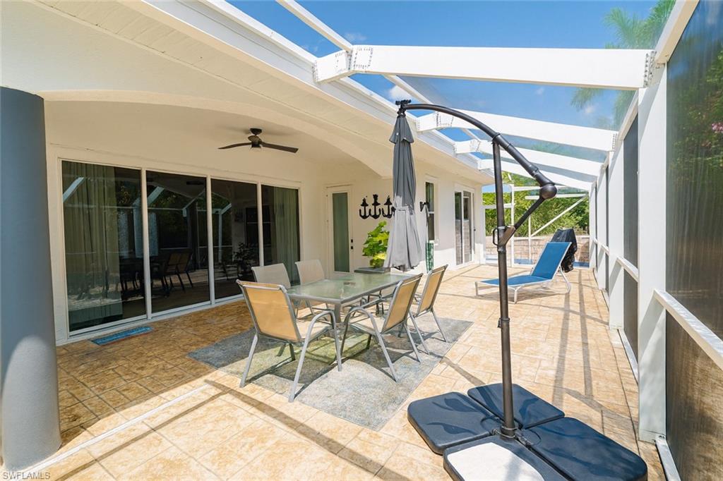 1975 San Marco Road Marco Island, FL 34145 - Photo 16 of 46 View of patio with outdoor dining area, glass enclosure, ceiling fan, and a sunroom