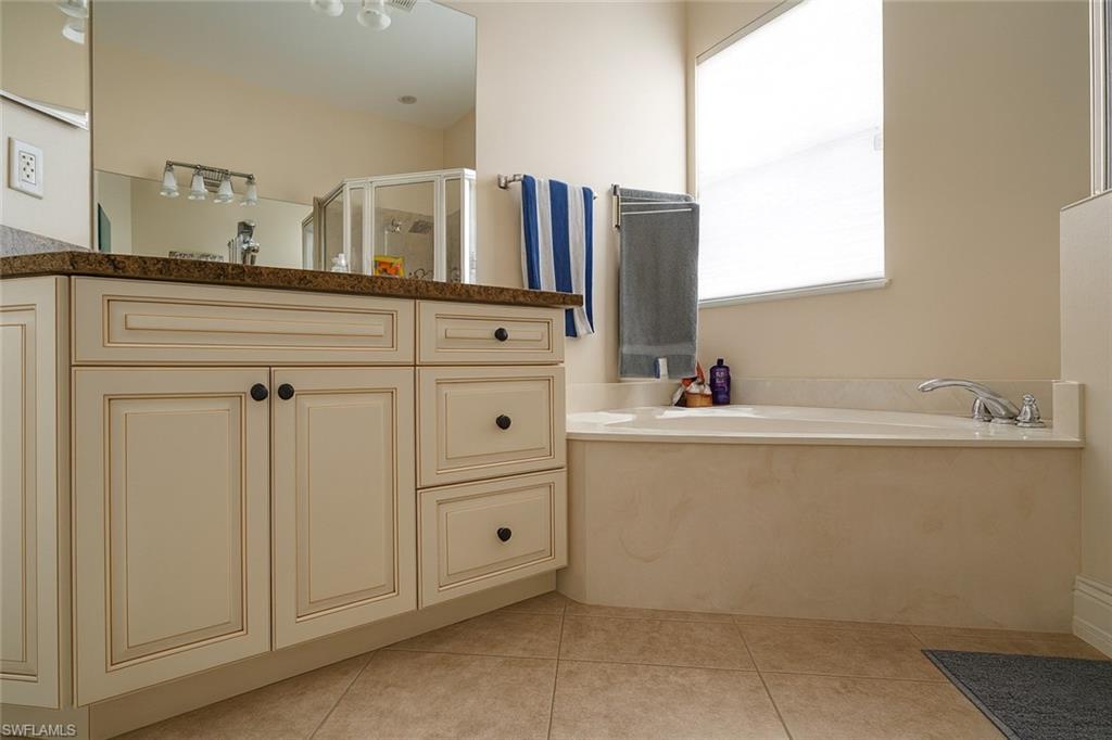 1975 San Marco Road Marco Island, FL 34145 - Photo 20 of 46 Full bath with light tile patterned floors, vanity, a bath, and a stall shower