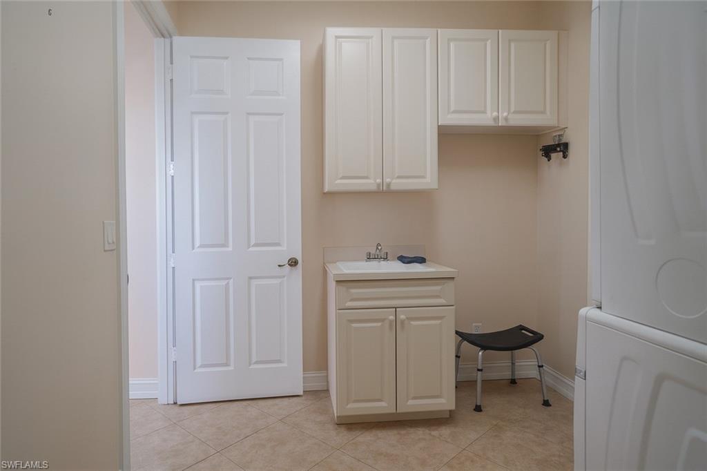 1975 San Marco Road Marco Island, FL 34145 - Photo 30 of 46 Laundry room with light tile patterned flooring and cabinet space
