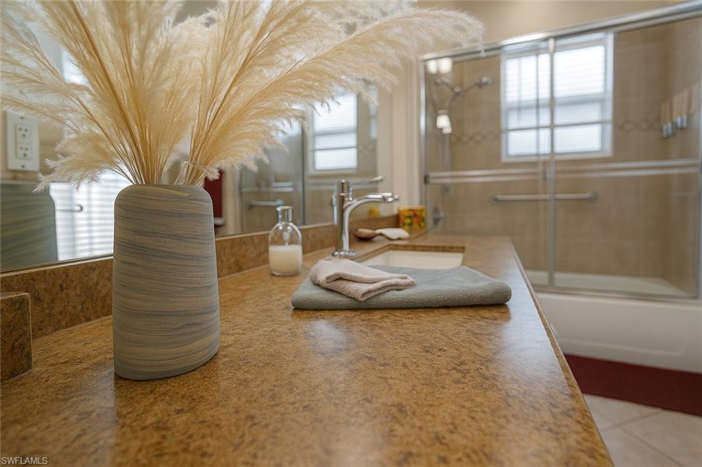 1975 San Marco Road Marco Island, FL 34145 - Photo 34 of 46 Bathroom with combined bath / shower with glass door, vanity, and light tile patterned flooring