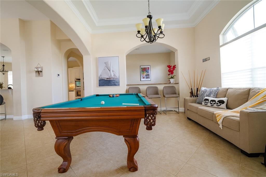 1975 San Marco Road Marco Island, FL 34145 - Photo 43 of 46 Recreation room featuring crown molding, a chandelier, billiards, light tile patterned floors, and arched walkways