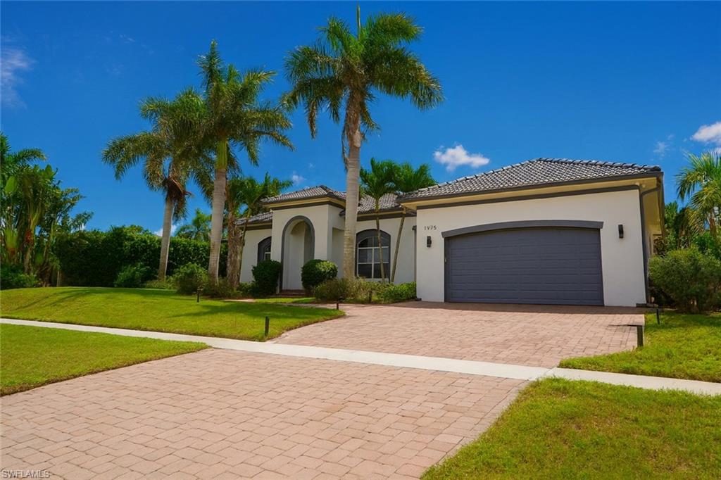1975 San Marco Road Marco Island, FL 34145 - Photo 5 of 46 Mediterranean / spanish house with a front yard, decorative driveway, stucco siding, and an attached garage