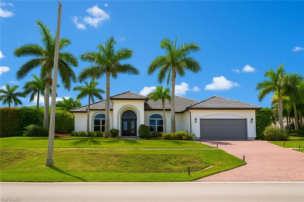 1975 San Marco Road Marco Island, FL 34145 - Photo 6 of 46 Mediterranean / spanish-style house featuring a front yard, a garage, decorative driveway, and stucco siding