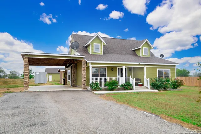 a view of a house with a porch and garden