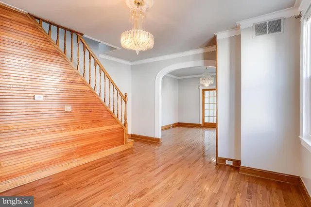 a view of a hallway with wooden floor and staircase