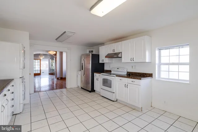 a large white kitchen with white cabinets