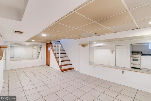a view of an empty room with stairs and a window