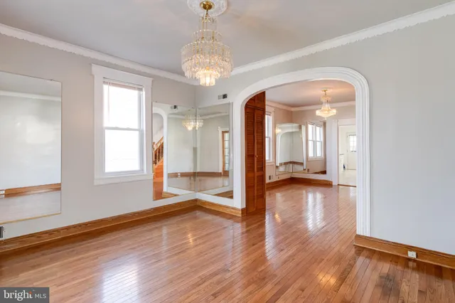 a view of a hallway with wooden floor and a chandelier