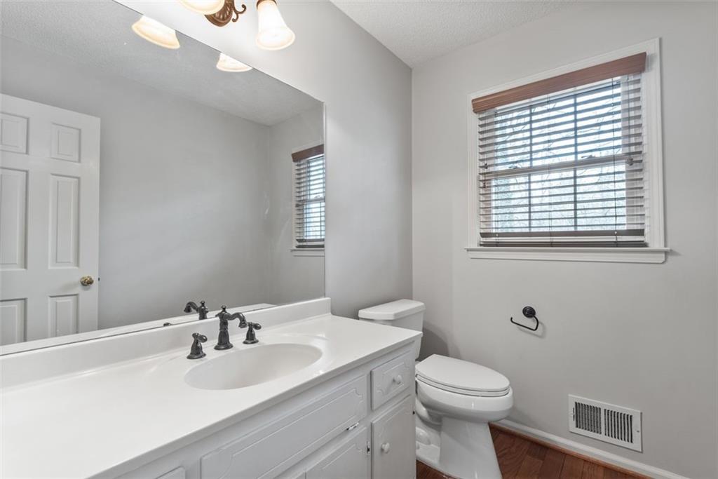 4803 Tarleton Drive Southwest Lilburn, GA 30047 - Photo 12 of 32 a bathroom with a toilet sink vanity and mirror