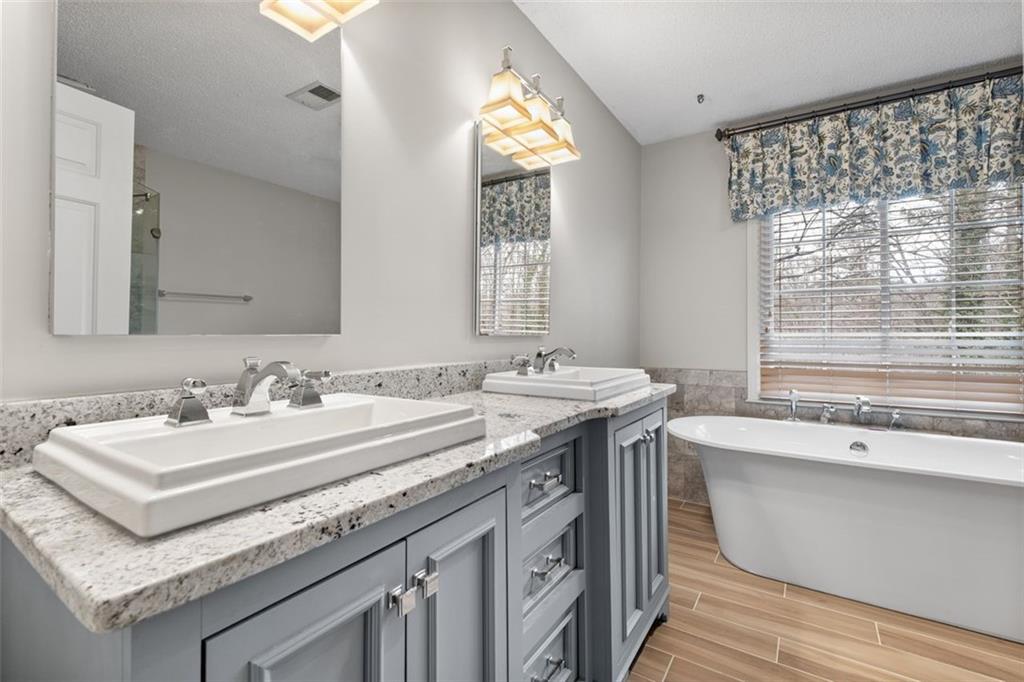 4803 Tarleton Drive Southwest Lilburn, GA 30047 - Photo 15 of 32 a bathroom with a granite countertop sink and a large mirror