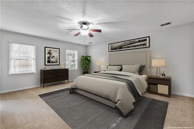 a spacious bedroom with a bed and dresser with wooden floor