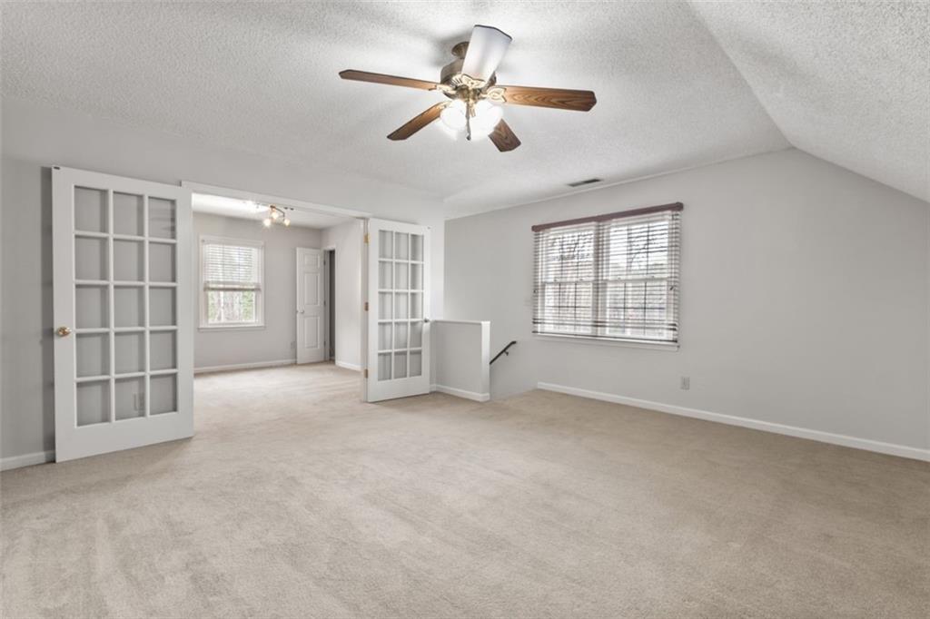 4803 Tarleton Drive Southwest Lilburn, GA 30047 - Photo 21 of 32 a view of an empty room with a window and a kitchen