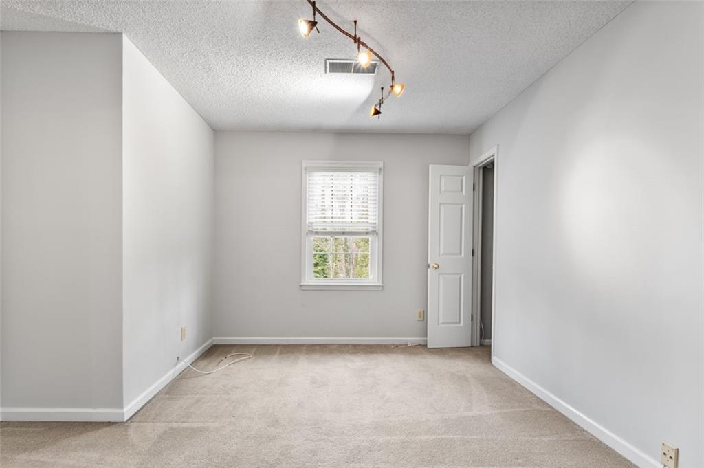 4803 Tarleton Drive Southwest Lilburn, GA 30047 - Photo 22 of 32 an empty room with windows