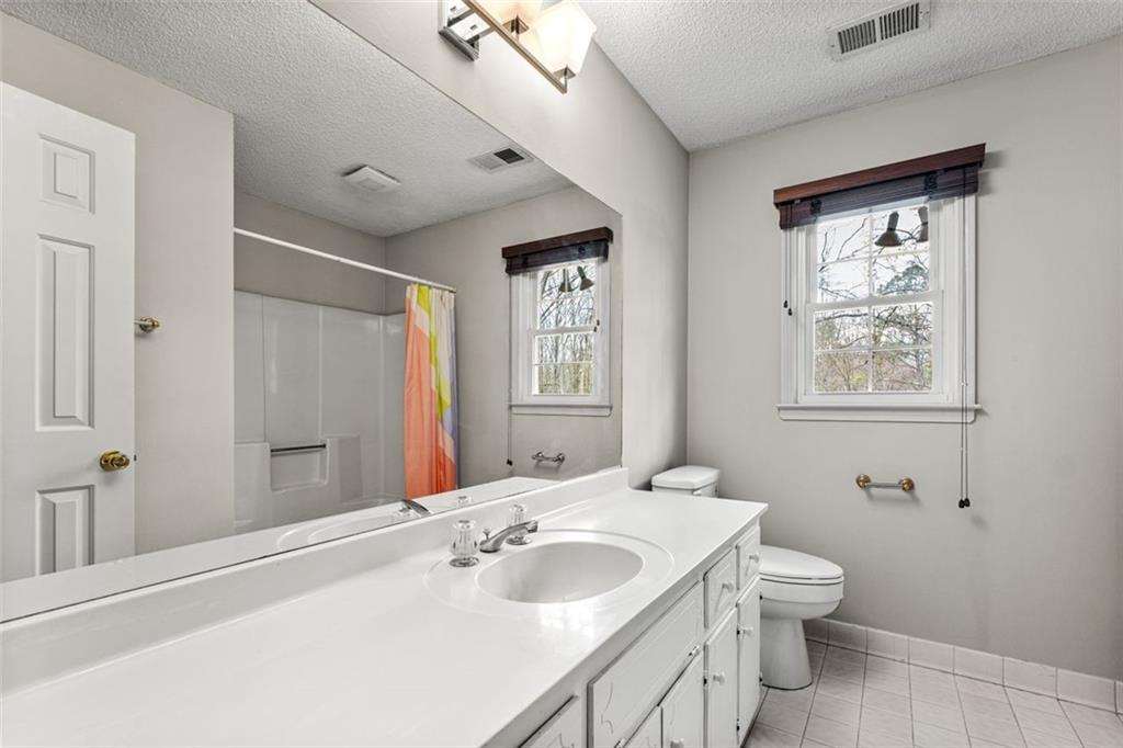 4803 Tarleton Drive Southwest Lilburn, GA 30047 - Photo 27 of 32 a bathroom with a sink and a mirror