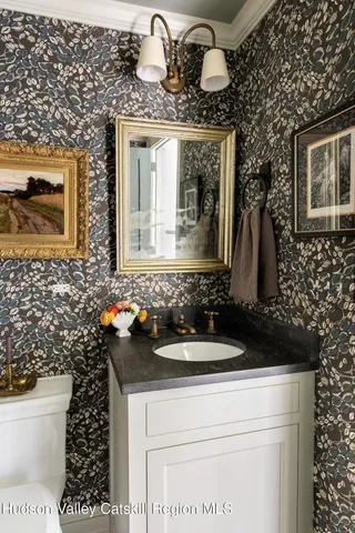 a bathroom with a sink a toilet and mirror