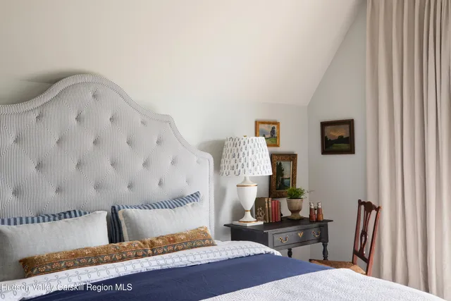 a bedroom with a bed and a flat tv screen on dresser