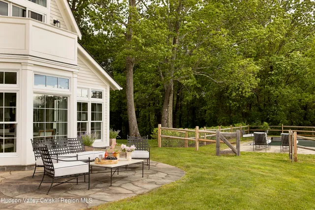 a view of a swimming pool with an ocean and trees in the background