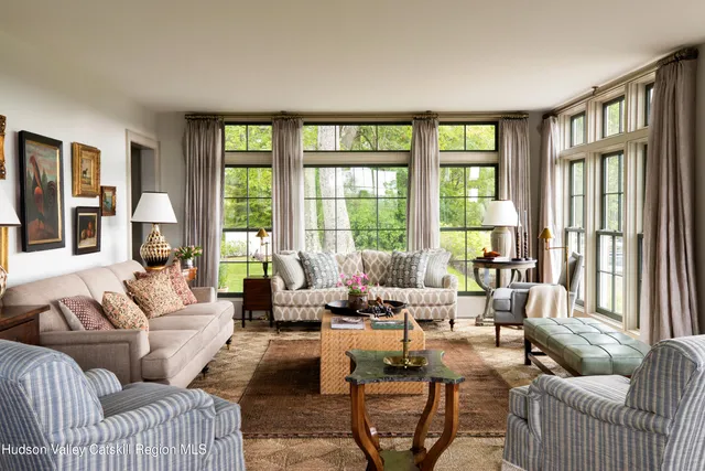 a living room with furniture and floor to ceiling windows