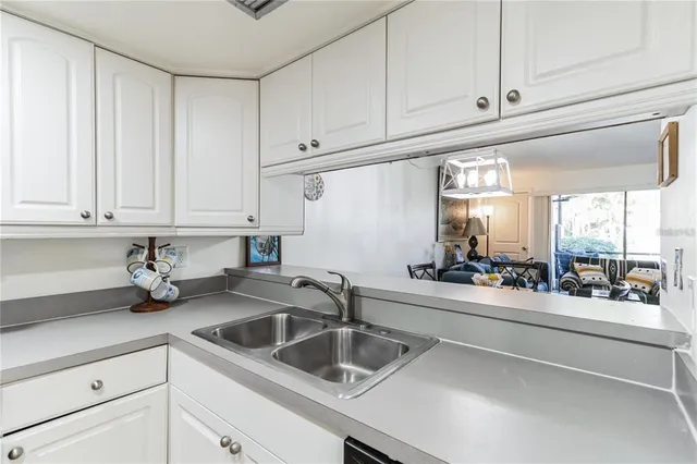 a kitchen with stainless steel appliances granite countertop a sink and white cabinets