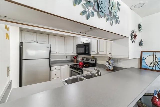 a kitchen with stainless steel appliances a refrigerator a sink a stove top oven a counter space and cabinets