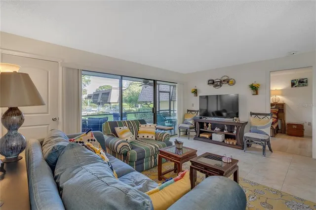 a living room with furniture a flat screen tv and a large window