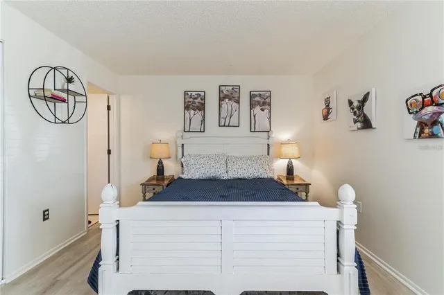 a spacious bedroom with a bed and a chandelier