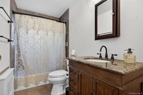 a bathroom with a granite countertop sink toilet and shower
