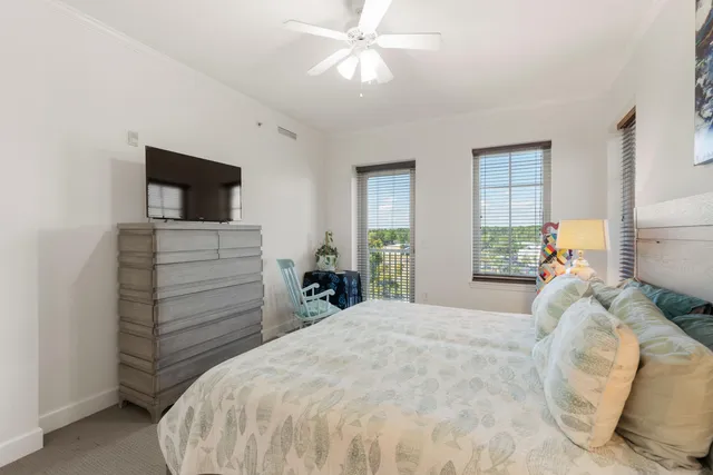 a bedroom with a bed and a flat tv screen on dresser