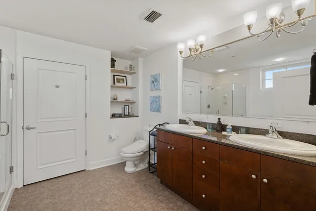 a spacious bathroom with a granite countertop sink a toilet and a mirror
