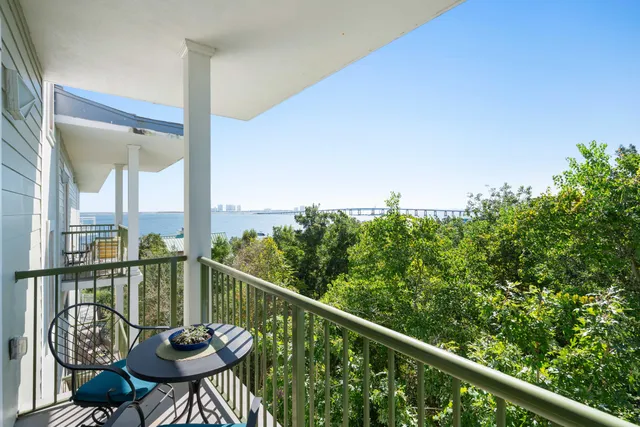 a view of a balcony with table and chairs and wooden fence