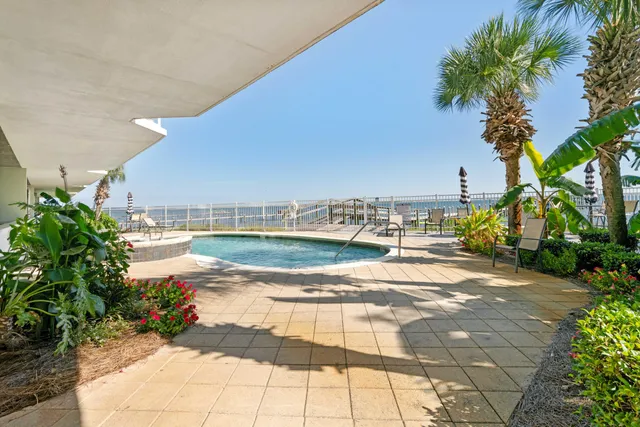 a view of a terrace with lawn chairs