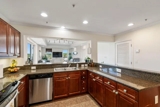 a kitchen with a sink and a stove top oven with wooden floor