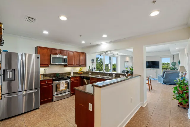 a kitchen with stainless steel appliances granite countertop a sink stove and refrigerator