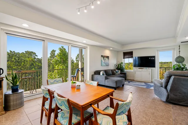 a living room with furniture a flat screen tv and a large window