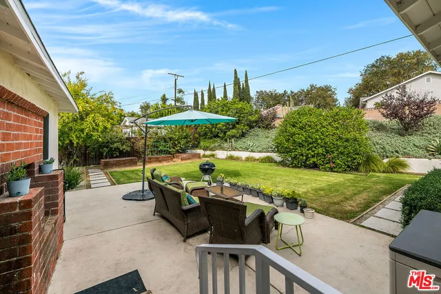 a view of a patio with furniture and a yard