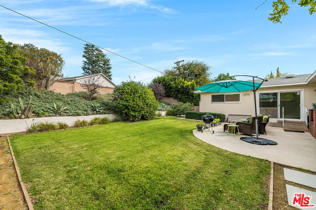 a view of a house with backyard sitting area and garden