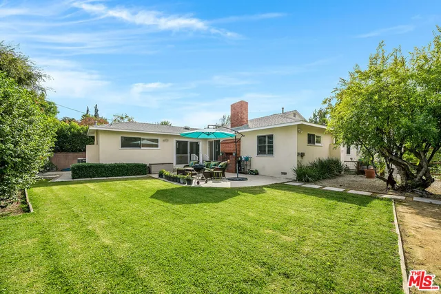 a view of a house with backyard and sitting area