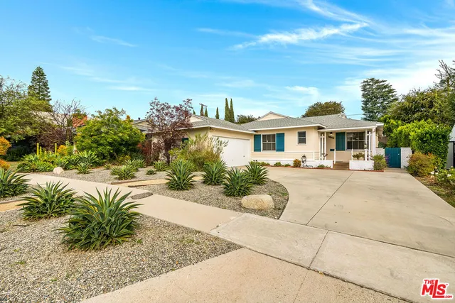 a front view of a house with a garden