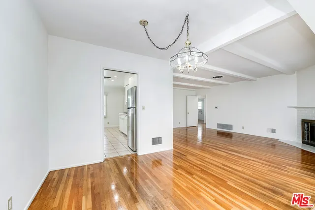 a view of a livingroom with wooden floor and staircase