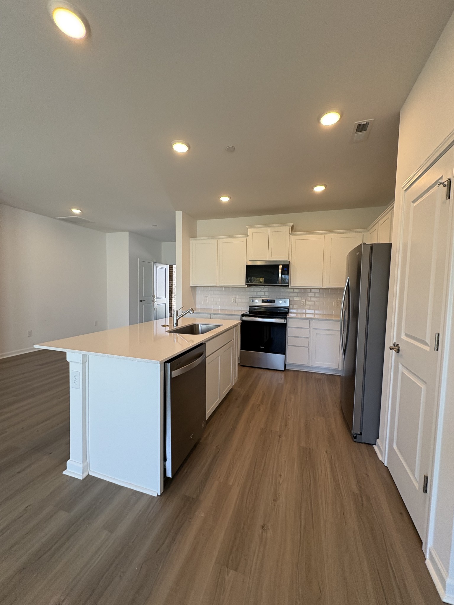7119 Mapleside Lane, Unit 47 Fairview, TN 37062 - Photo 4 of 5 an open kitchen with wooden floor and stainless steel appliances