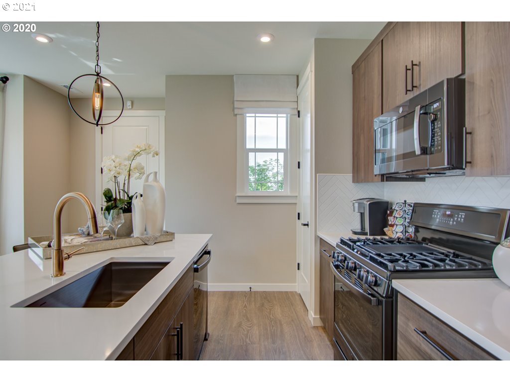 8229 Southeast Kinnaman Road Hillsboro, OR 97123 - Photo 16 of 21 a kitchen with stainless steel appliances a sink a stove and cabinets