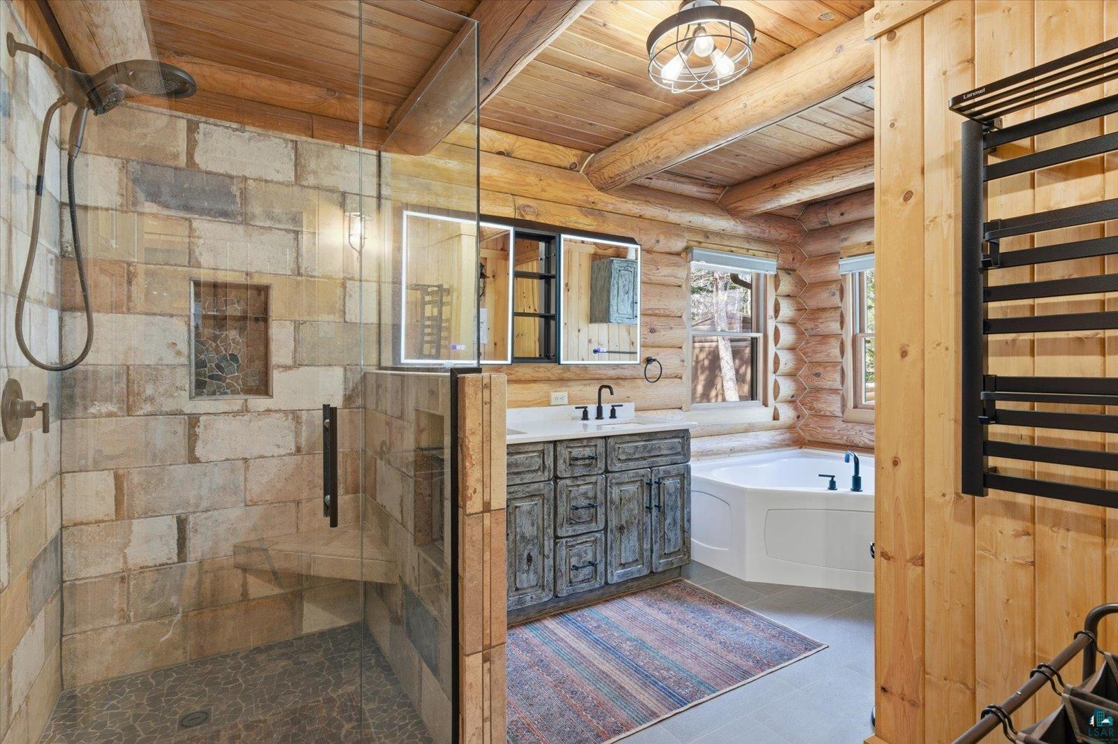 7185 Giants Ridge Road Embarrass, MN 55732 - Photo 22 of 47 Spacious bathroom featuring a glass-enclosed walk-in shower with stone-look tile, a built-in bench, and a corner soaking tub