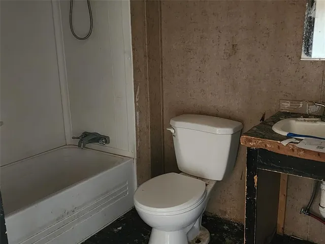 a bathroom with a toilet and a tub