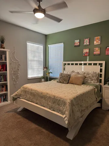 a bedroom with a bed and a lamp on dresser