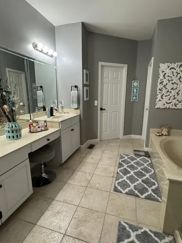 a house that is sitting in the grass with large trees