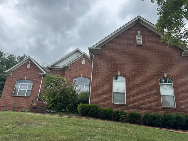 front view of brick house with a yard
